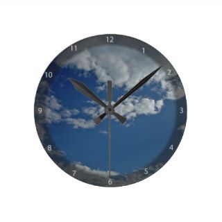 Cat head shaped piece of sky between clouds round clock