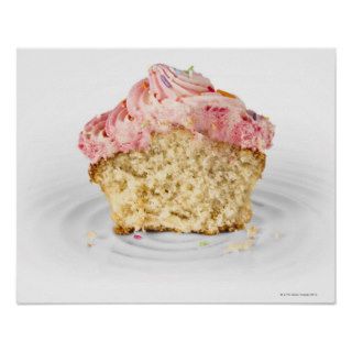 Pink cup cake sat on a porcelain cake stand, on print