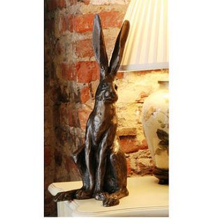 sitting hare sculpture by candle and blue