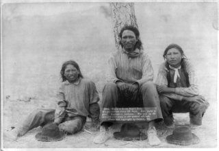 photograph Three of Uncle Sam's Pets. We get rations every 29 days Three Lakota teenage boys in western clothing, sitting near a tree, probably on or near Pine Ridge Reservation. Grabill, John C. H., photographer. Three of Uncle Sam's Pets. We get