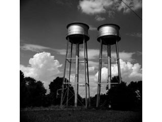 Water tanks against cloudy sky Poster Print (18 x 24)